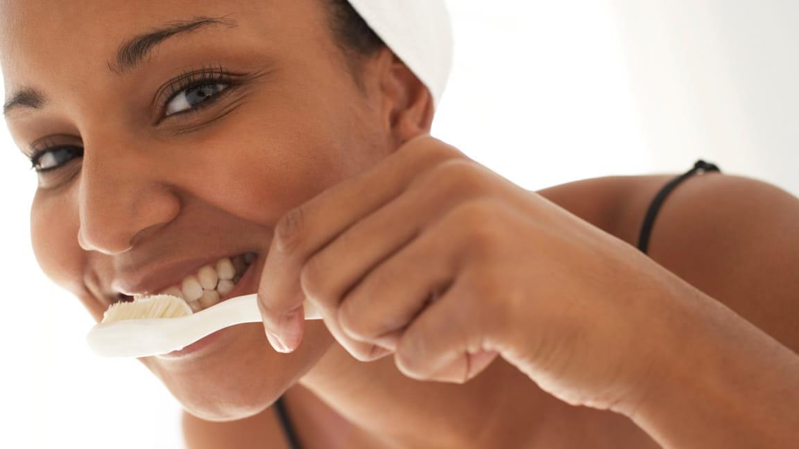 young woman brushes her teeth